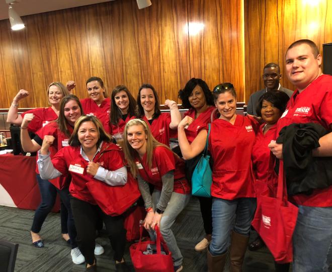 Group photo of nurses gathered in red scrubs for Lobby Day