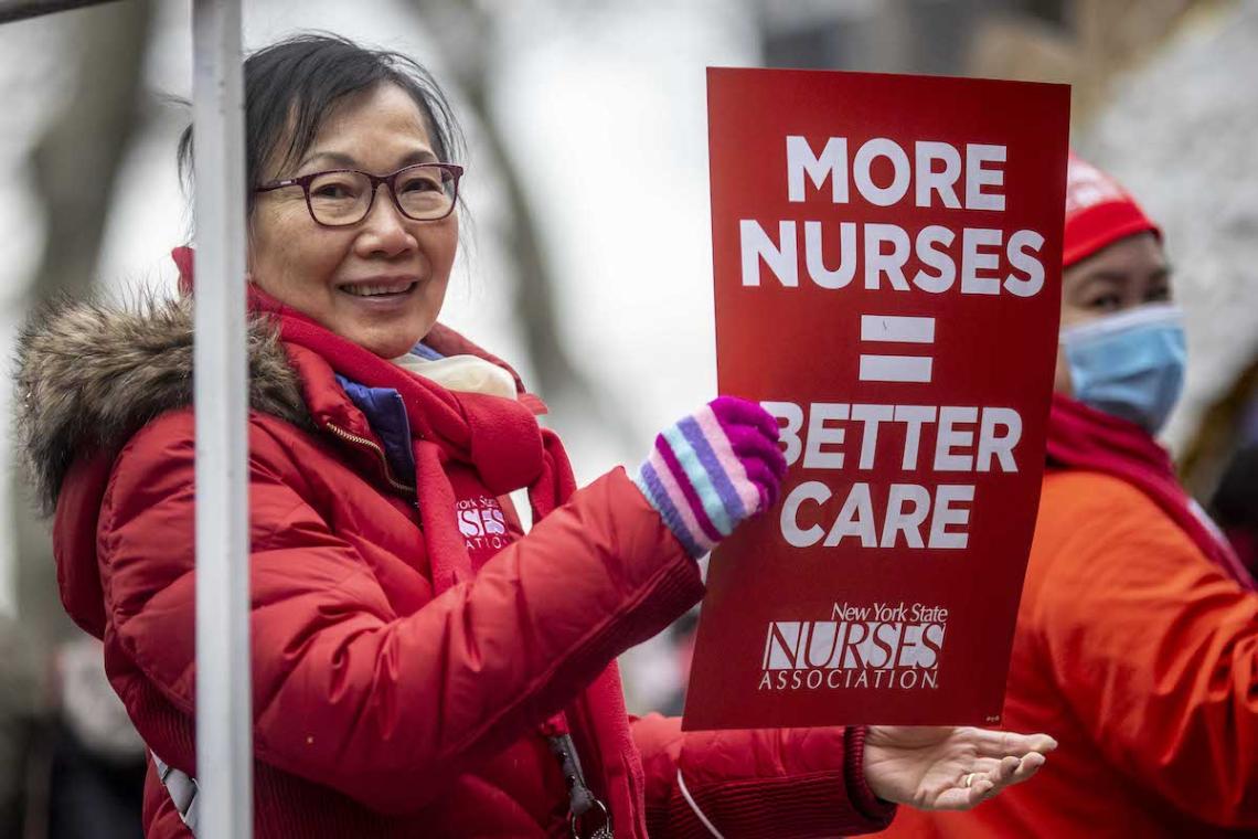 NYSNA member holds up sign that says "More Nurses = Better Care" at the2023 Lunar Year Parade