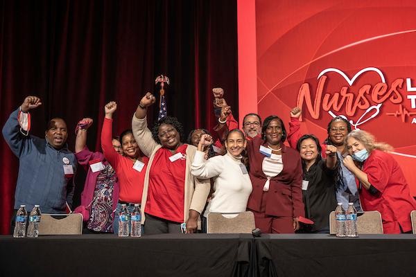 NYSNA leaders pose on stage to celebrate NYSNA's accomplishments at the 2023 NYSNA Convention