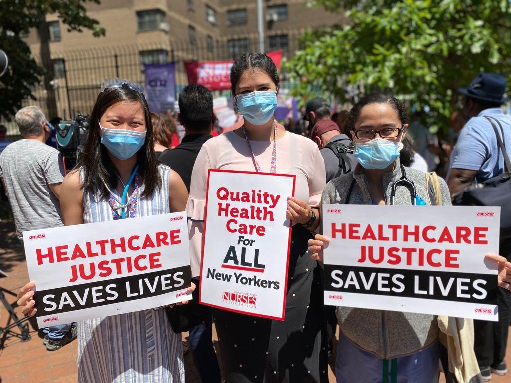 Nurses hold signs that say Quality Health Care For All New Yorkers