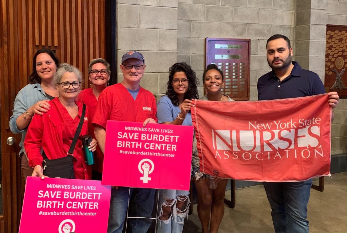 Nurses hold signs saying Save Burdett Birth Center and hold a NYSNA banner