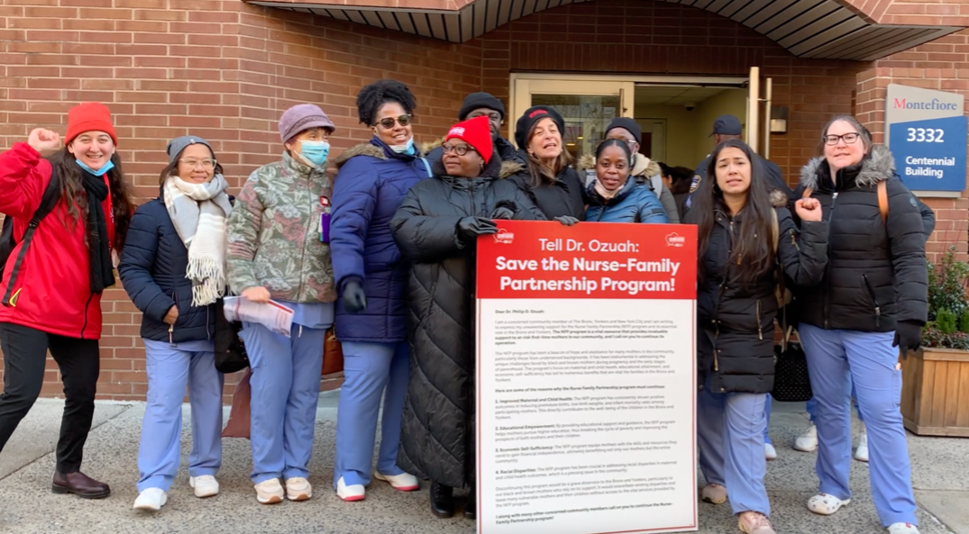 Montefiore Bronx Nurses gather outside the CEO's office with a poster board of signature