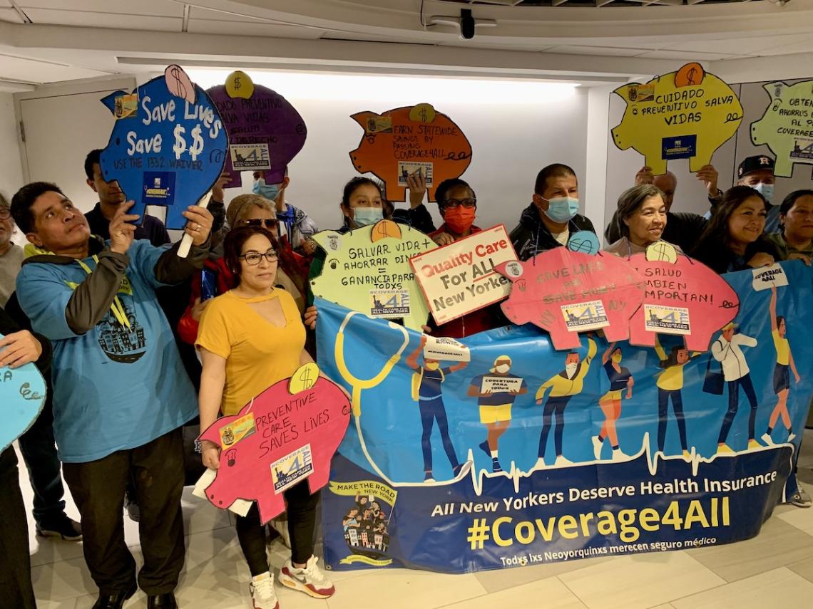 Advocates hold #Coverage4All signs