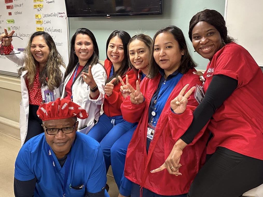 Lincoln Hospital nurses in scrubs smiling with peace hand signs