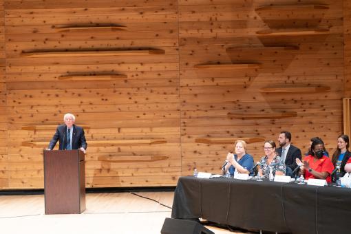 Senator Bernie Sanders stands at a podium next to NYSNA and RWJUH nurses during Safe Staffing Hearing in November 2023