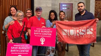 Nurses hold signs saying Save Burdett Birth Center and hold a NYSNA banner