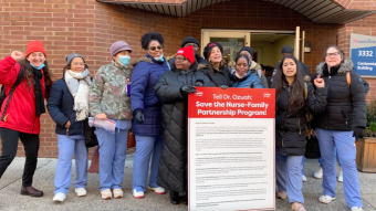 Montefiore Bronx Nurses gather outside the CEO's office with a poster board of signature