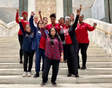 Nurses standing at the stairs in the NY Capitol Building with their fists up