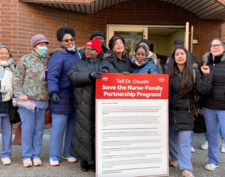 Montefiore Bronx Nurses gather outside the CEO's office with a poster board of signature