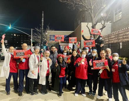 Elmhurst nurses gather outside the hospital with signs demanding Safe R.N. Staffing 