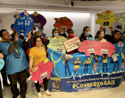 Advocates hold #Coverage4All signs