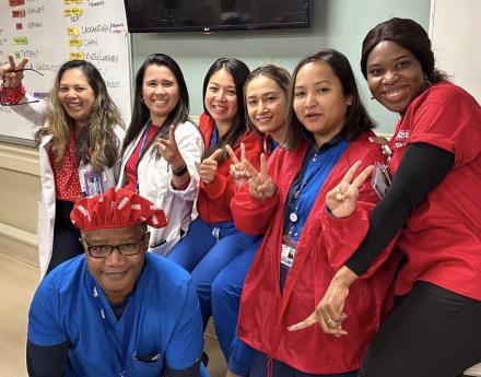 Lincoln Hospital nurses in scrubs smiling with peace hand signs